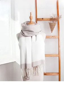 Detail of color-block knit scarf with tassel fringe on a mannequin in cozy studio