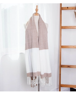 Detail of color-block scarf with fringes and twill texture on a model stand