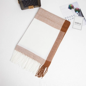 Flat lay of soft white and brown gradient plaid cashmere-feel scarf with mixed fringe
