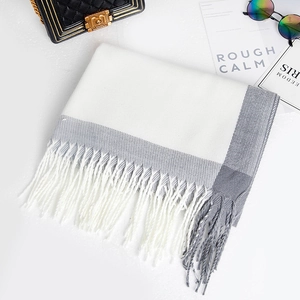Detail of grey and white color block pashmina scarf featuring long fringe tassels