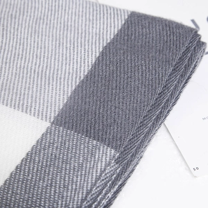 Macro shot of gray and white checkered cashmere-style scarf with fine knit texture