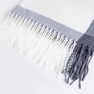 Close-up of white and grey plaid cashmere scarf with soft tassel fringe details