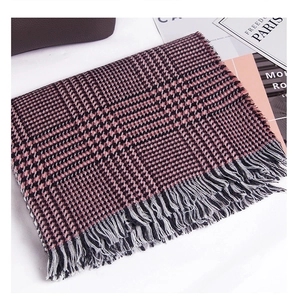 Detailopname van de rood-zwarte pied-de-poule sjaal met fijne franjes voor de winter