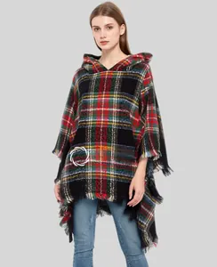 Close-up of green plaid hooded poncho featuring soft fringe tassels and classic tartan pattern
