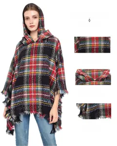 Detail of red and green plaid hooded poncho showing soft knit fabric and tassel trim