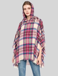 Detail of multi-colored plaid hooded poncho with classic fringe trim and warm knit fabric