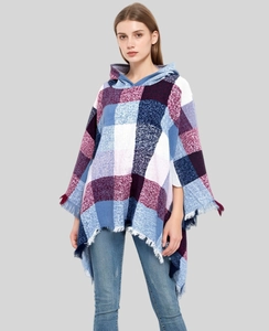 Detail of blue and red plaid hooded poncho featuring soft knit fabric and fringe trim