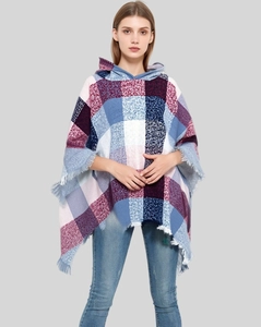 Detail of colorful plaid hooded poncho showing soft knit texture and fringed edges
