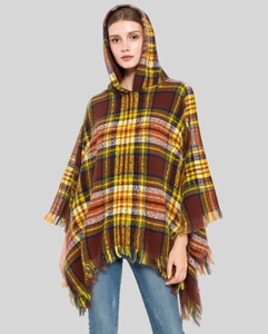 Detail of plaid hooded poncho featuring warm autumn tones and classic fringe tassels