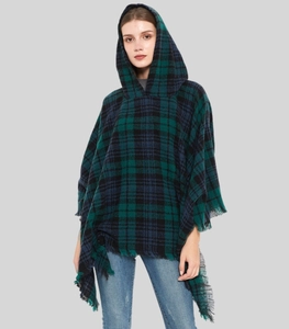 Close-up of green and blue plaid hooded shawl featuring fringe edges and soft knit fabric
