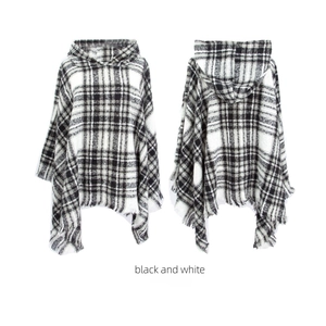 Detailed front and back view of black and white plaid hooded poncho with tassel trim