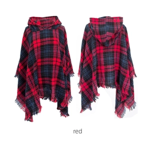 Detail view of red plaid hooded poncho featuring fringe trim and soft textured fabric