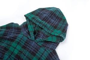 Detail of green and blue plaid hooded shawl featuring premium brushed knit fabric texture