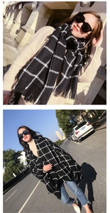 Detail of black and white plaid scarf featuring soft texture and fine fringe tassels
