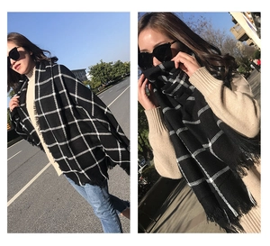 Detailed close-up of a classic black and white plaid scarf featuring elegant tassel edges