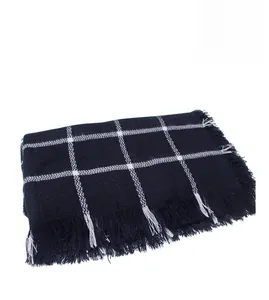 Detailed view of classic black and white checkered scarf featuring fringe tassel edges