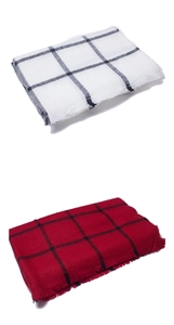 Close-up of black-white and red-black checkered scarves with tassel edge details
