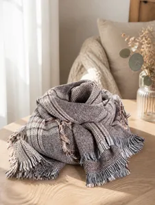 Close-up of houndstooth plaid scarf with soft fringe trim on a mannequin for winter