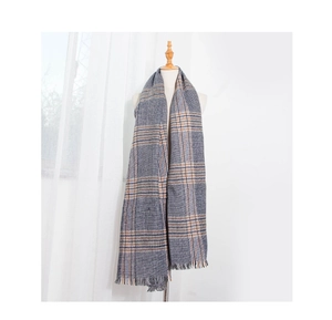 Close-up of grey and orange houndstooth scarf with soft fringe and thick knit texture