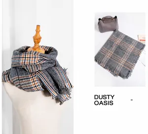 Detail of grey houndstooth scarf showing orange knit patterns and fringe edges