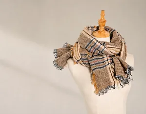 Detail of soft earth-tone plaid scarf with fringes and thick cashmere-like texture