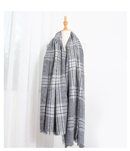 Close-up of thick houndstooth plaid scarf showing soft texture and fine fringe details