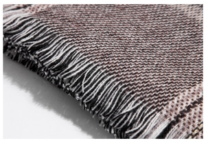 Macro shot of houndstooth scarf showing fine fringes and thick cashmere texture