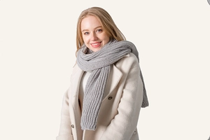 Close-up detail of grey knitted scarf showing thick ribbed texture and warm acrylic material