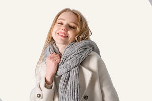 Close-up of grey chunky knit scarf texture paired with a beige double-breasted wool coat