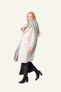 Gray chunky knit scarf paired with a beige long coat and black wide-leg trousers