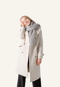 Detailed close-up of heavy knit gray scarf paired with a beige double-breasted coat