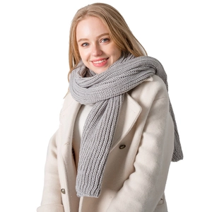 Long light grey acrylic knit scarf with thick ribbed texture worn by a model