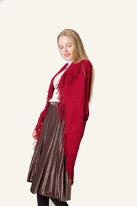 Gros plan d'un poncho en maille rouge avec franges et texture tricotée fine