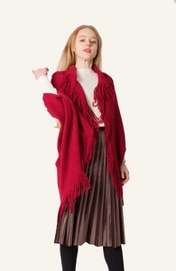Détail d'un châle tricoté rouge avec de longues franges et un drapé bohème élégant