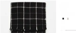 Detail view of black and white plaid scarf featuring soft brushed texture and fringe trim