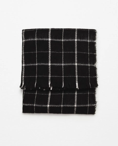 Close-up of black and white windowpane plaid scarf with detailed fringe texture
