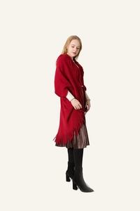 Détail du châle en maille rouge souple avec franges denses et un drapé élégant