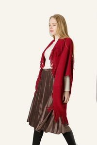 Détail du châle en tricot rouge avec franges élégantes porté avec une jupe plissée