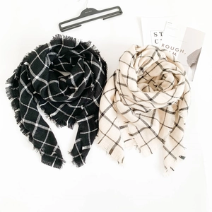 Detailed close-up of classic black and white plaid scarves with soft fringe edges