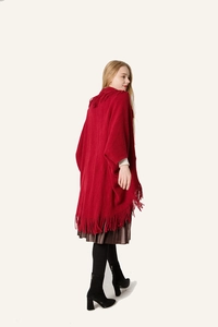 Détail d'un châle en tricot rouge avec d'élégantes franges longues et texture de qualité
