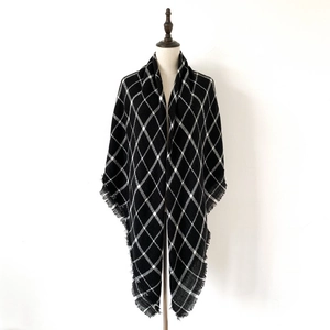 Detail of classic black and white checkered shawl featuring fringed tassel edges