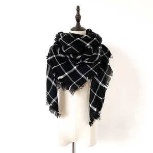 Detailed view of black and white checkered scarf with fringe on a mannequin torso