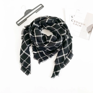 Close-up of black and white checkered scarf with soft texture and fringe details