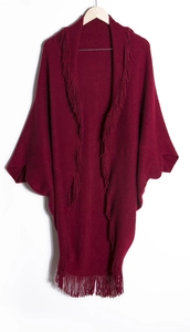 Détail du cardigan en maille rouge foncé avec franges bohèmes et manches chauve-souris