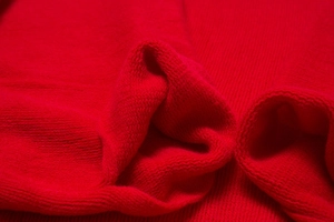 Vue détaillée de la maille rouge douce et de la finition bord-côte du pull cardigan