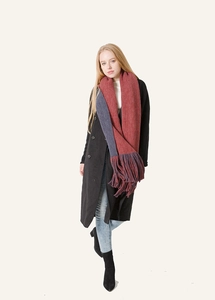 Detail of thick knit scarf with long tassels in brick red and navy blue patchwork