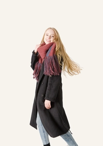 Red and blue color block scarf with long tassels paired with a long black wool coat