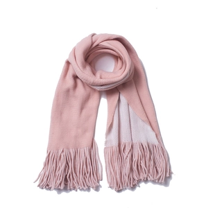 Close-up of pink knitted winter scarf featuring soft fabric texture and long tassels