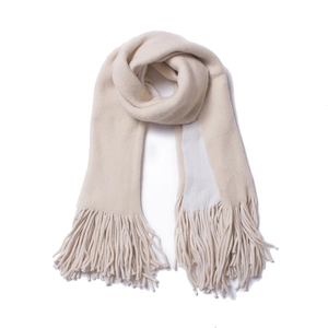 Close-up of thick beige winter scarf featuring dense tassel details and soft knit texture