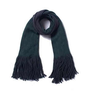 Close-up of deep green knit scarf featuring thick warm texture and long fringe tassels